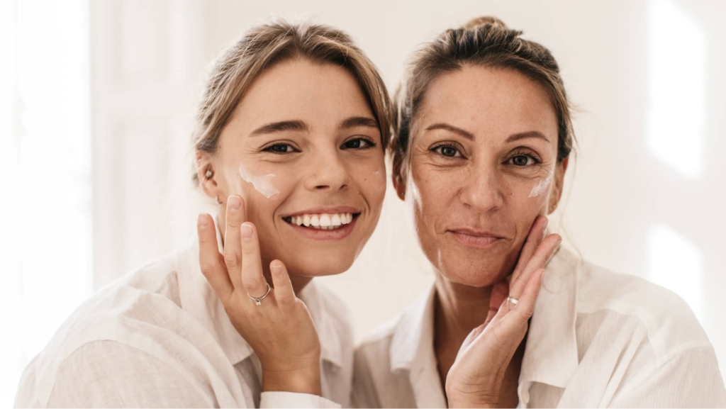 Nahaufnahme von zwei Frauen, die sich das Gesicht mit Creme einreiben